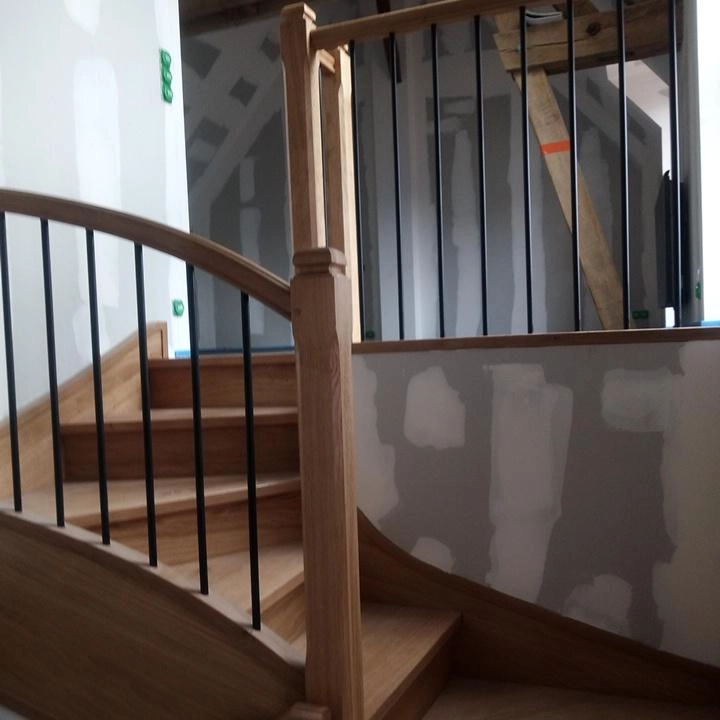 Escalier en chêne à double révolution avec garde-corps métal, réalisé par Ébénisterie Sornay Cédric, artisan menuisier à Sens dans l’Yonne