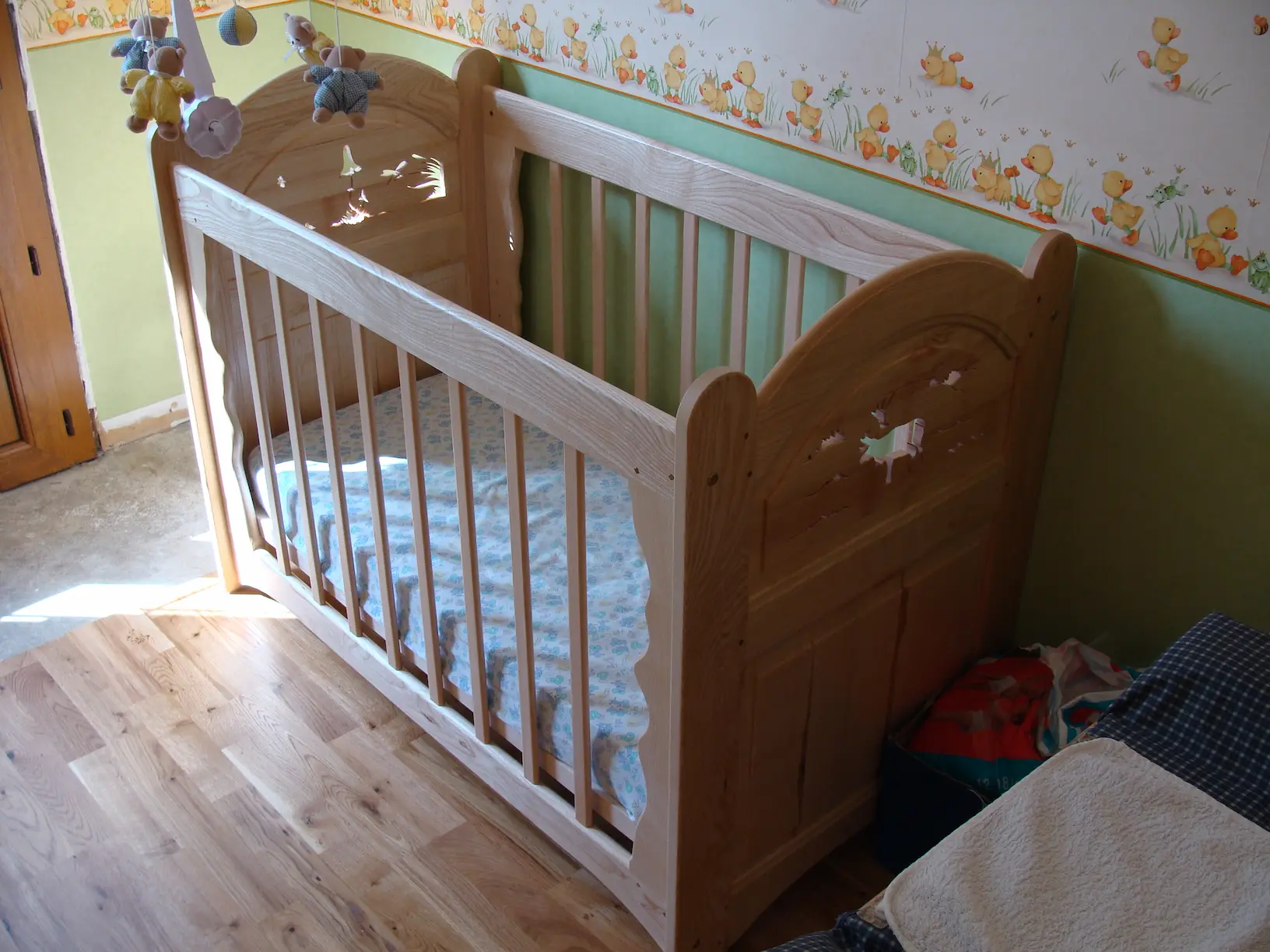 Lit bébé en frêne massif avec découpes décoratives, réalisé par Ébénisterie Sornay Cédric, artisan ébéniste à Sens dans l’Yonne