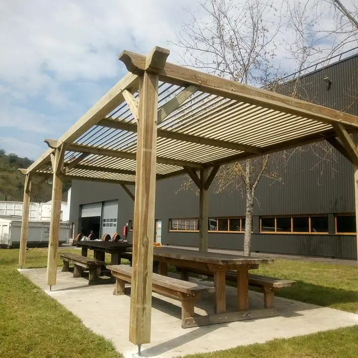 Pergola extérieure en épicéa autoclave avec tables et bancs fixes, réalisée par Ébénisterie Sornay Cédric, artisan menuisier agenceur à Sens dans l’Yonne
